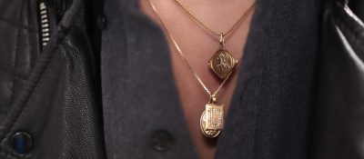 closeup of layered gold necklaces and unbuttoned collar