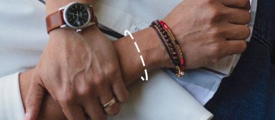 man close up of arms and wrists with bracelets and watch