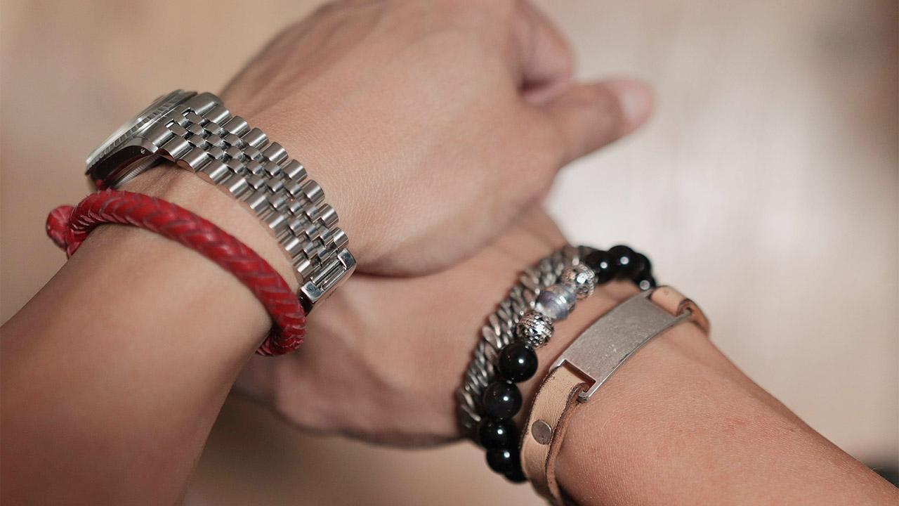 hands folded together with bracelets on both wrists 