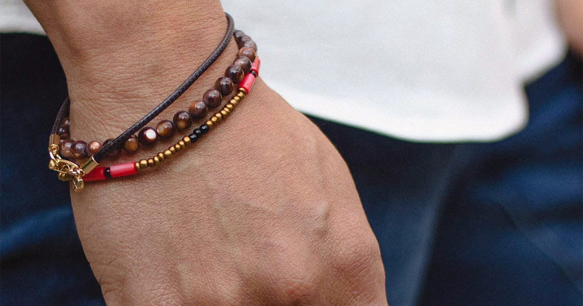 closeup of man's wrist with beaded and cord bracelets