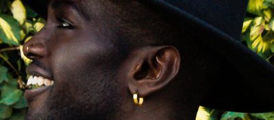 close up of black man wearing gold earring