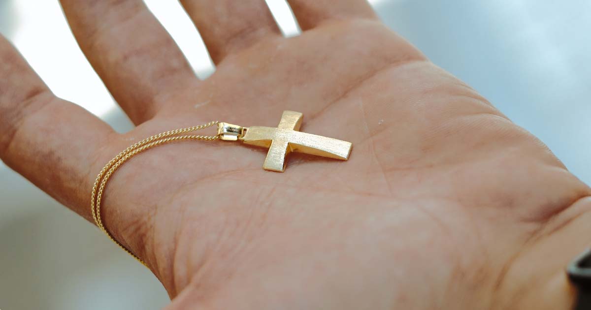 cross necklace in hand