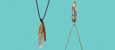 feather charm necklace on teal background