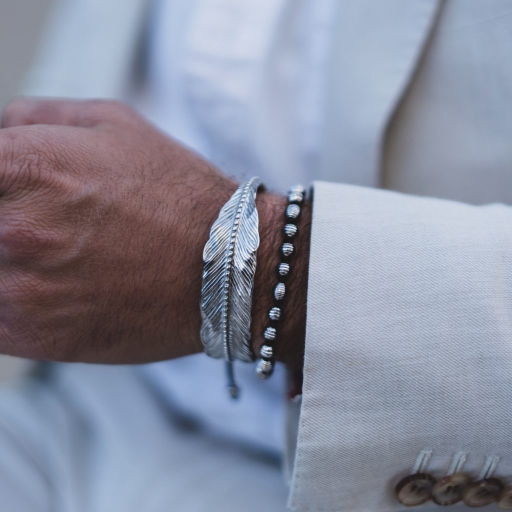 close up of man's wrist wearing feather cuff bracelet from elegatto