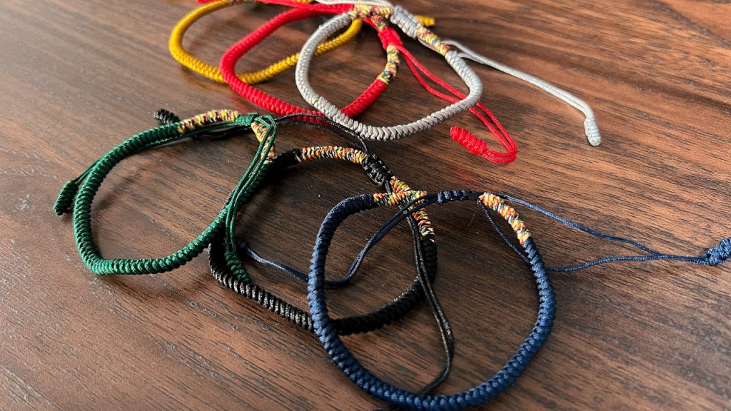 6 colorful braided bracelets on wood table
