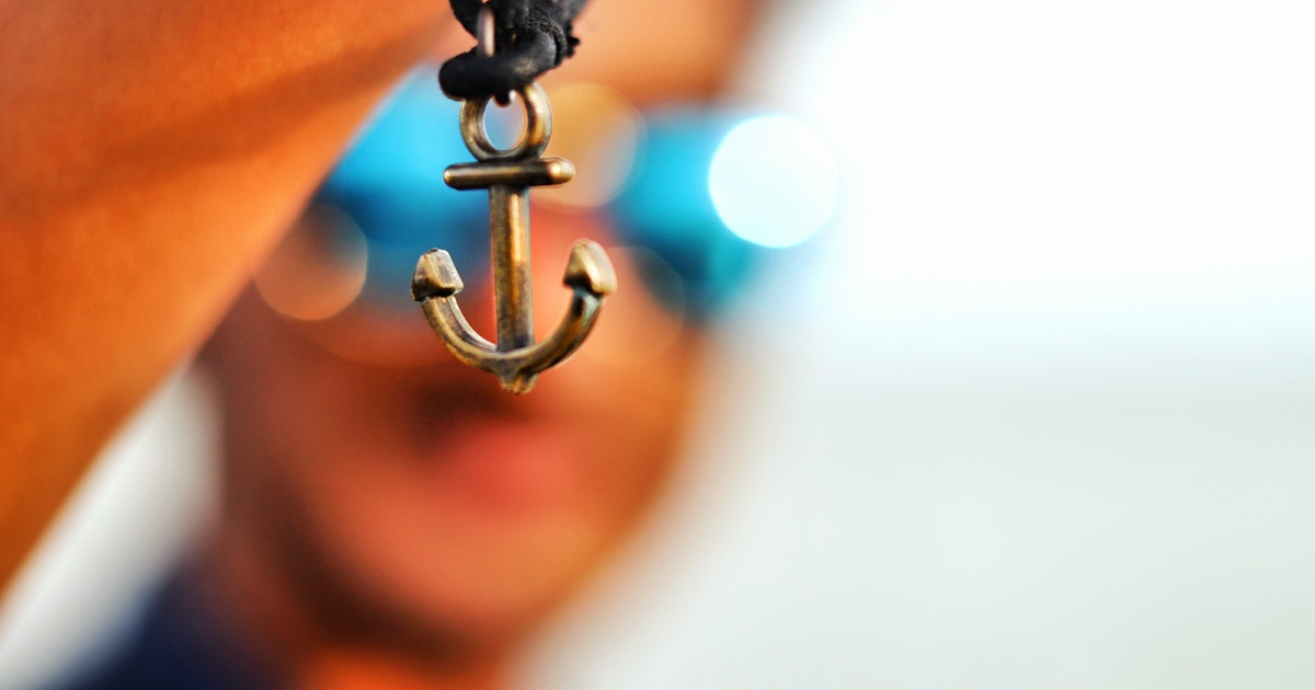 closeup of anchor charm on men's cord bracelet