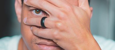 black ring closeup on finger with eye