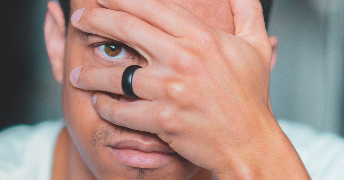 black ring closeup on finger with eye